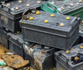 Battery waste. Pile of old used EV car batteries toxic waste chemicals lead leak impact nature no recycled.